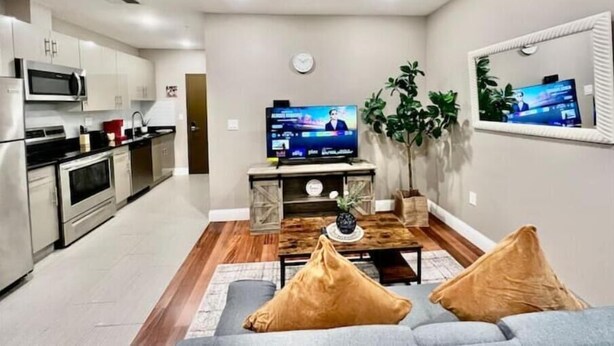 A modern living room with a sofa, coffee table, and a flat-screen TV. - 405 Spacious and superior 1BDR APT in center city (Philadelphia)
