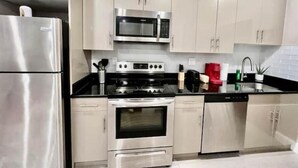 A modern kitchen with stainless steel appliances, including a refrigerator, microwave, stove, and dishwasher. - 405 Spacious and superior 1BDR APT in center city (Philadelphia)