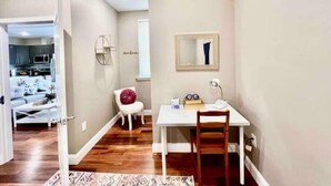 A compact living space with a kitchenette, a dining area with a white table and chair, and a small seating area with a red cushion. - 504 Luexy 1BDR apt in center city (Philadelphia)