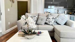 A modern living room with a beige sofa, a white coffee table, and a decorative plant. - 504 Luexy 1BDR apt in center city (Philadelphia)