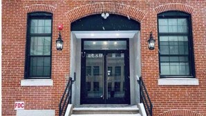 A brick building with a double door entrance, two windows on either side, and a staircase leading up to the door. - 504 Luexy 1BDR apt in center city (Philadelphia)