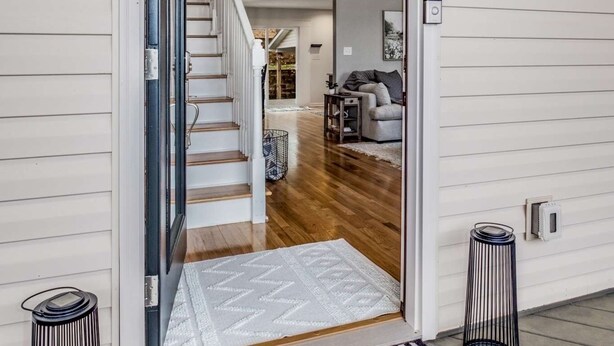 Eine Treppe führt zu einer zweiten Etage mit Blick auf ein Wohnzimmer.