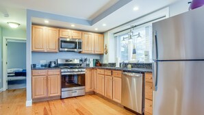 Una cocina moderna con armarios de madera, electrodomésticos de acero inoxidable y un refrigerador grande.