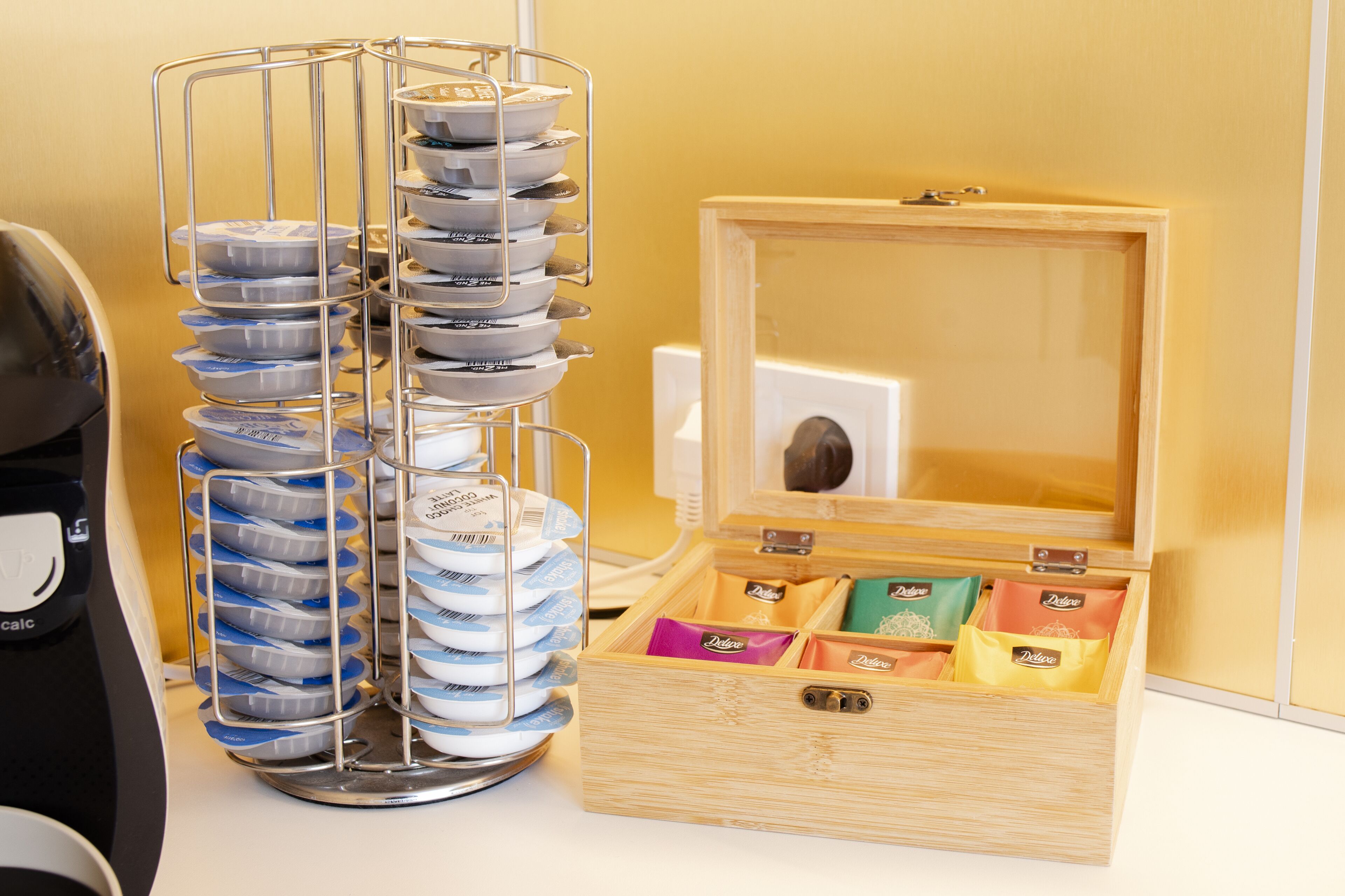 Una estructura metálica con múltiples bandejas de alimentos envasados junto a una caja de madera abierta que contiene más alimentos envasados.