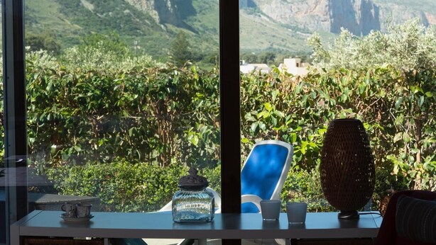 Une table placée devant une fenêtre offrant une vue sur un paysage montagneux.