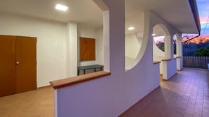 Un pasillo con un banco de madera, una puerta y una ventana.