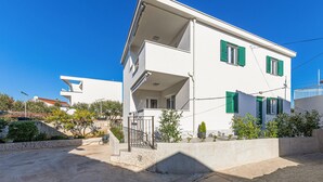A two-story building with a balcony, white walls, and green shutters. - 2 bedroom awesome apartment in Okrug Gornji (Okrug Gornji)