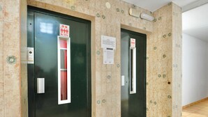 Two elevator doors with a maximum weight limit sign, a handrail, and a safety notice. - Beachfront Apartment with Wifi and Easy Access to Attractions (Lloret de Mar)
