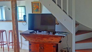 Ein Unterhaltungsschrank aus Holz mit Fernseher, einem Gemälde und einer Vase.