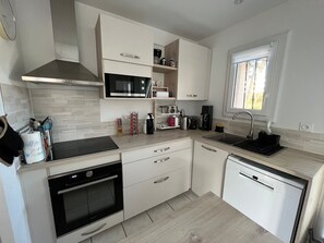 Una cucina moderna con forno a microonde, forno, lavello e lavastoviglie.