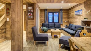 A cozy wooden interior with a sofa, chairs, and a table. - Spacious chalet in resort center, 10 people, pets allowed (La Plagne 1800)