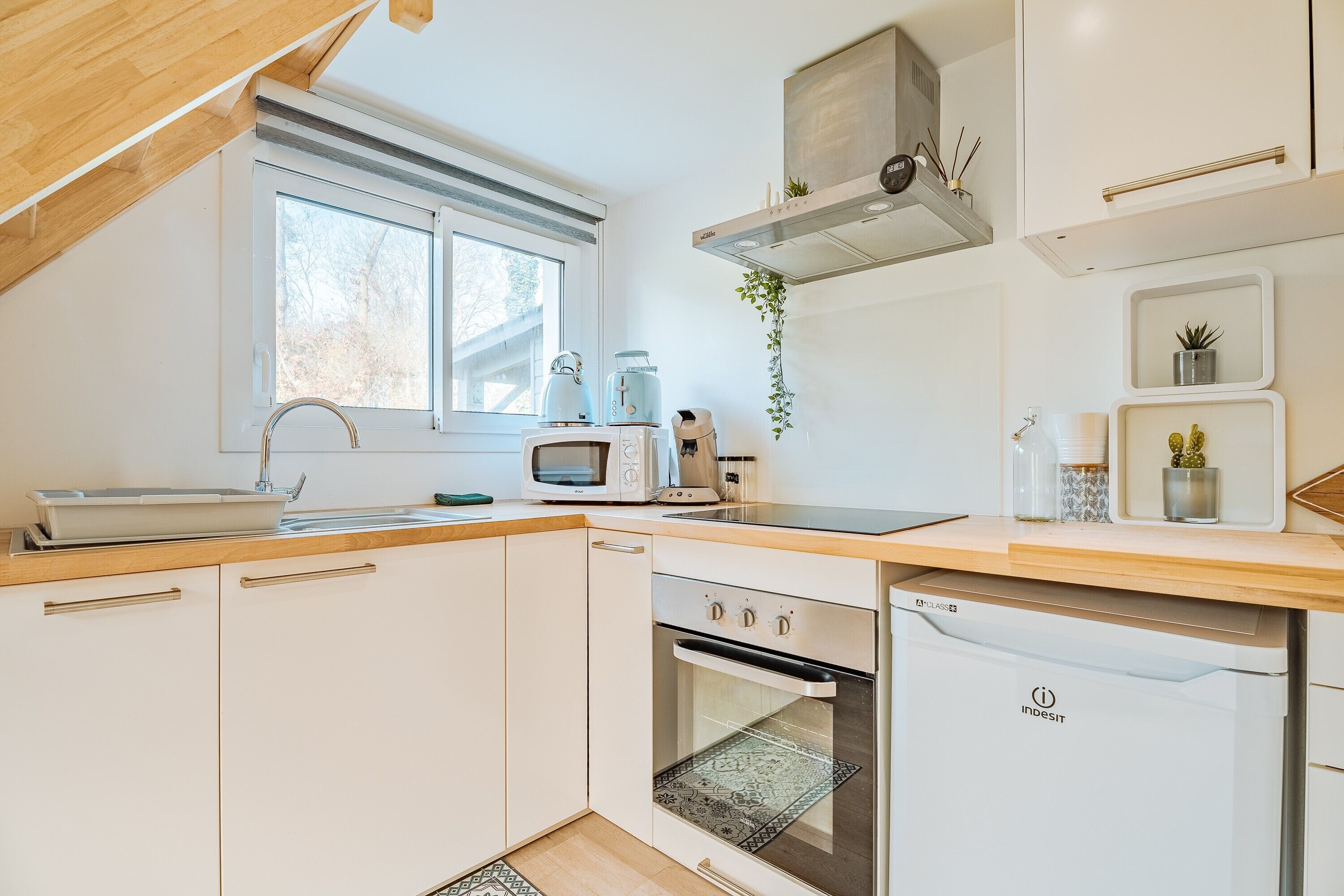 A modern kitchen with white cabinets, a built-in oven, a microwave, and a dishwasher.