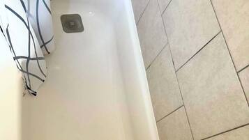 Un baño con bañera, ducha y retrete.
