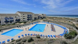 A pool area with two pools, sun loungers, and a view of the ocean. - 01426 _ Apartment 4 people, residence with pool, Lacanau Ocean (LACANAU OCEAN)