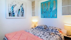 A bedroom with a bed, two wall-mounted lamps, and two paintings. - 01426 _ Apartment 4 people, residence with pool, Lacanau Ocean (LACANAU OCEAN)