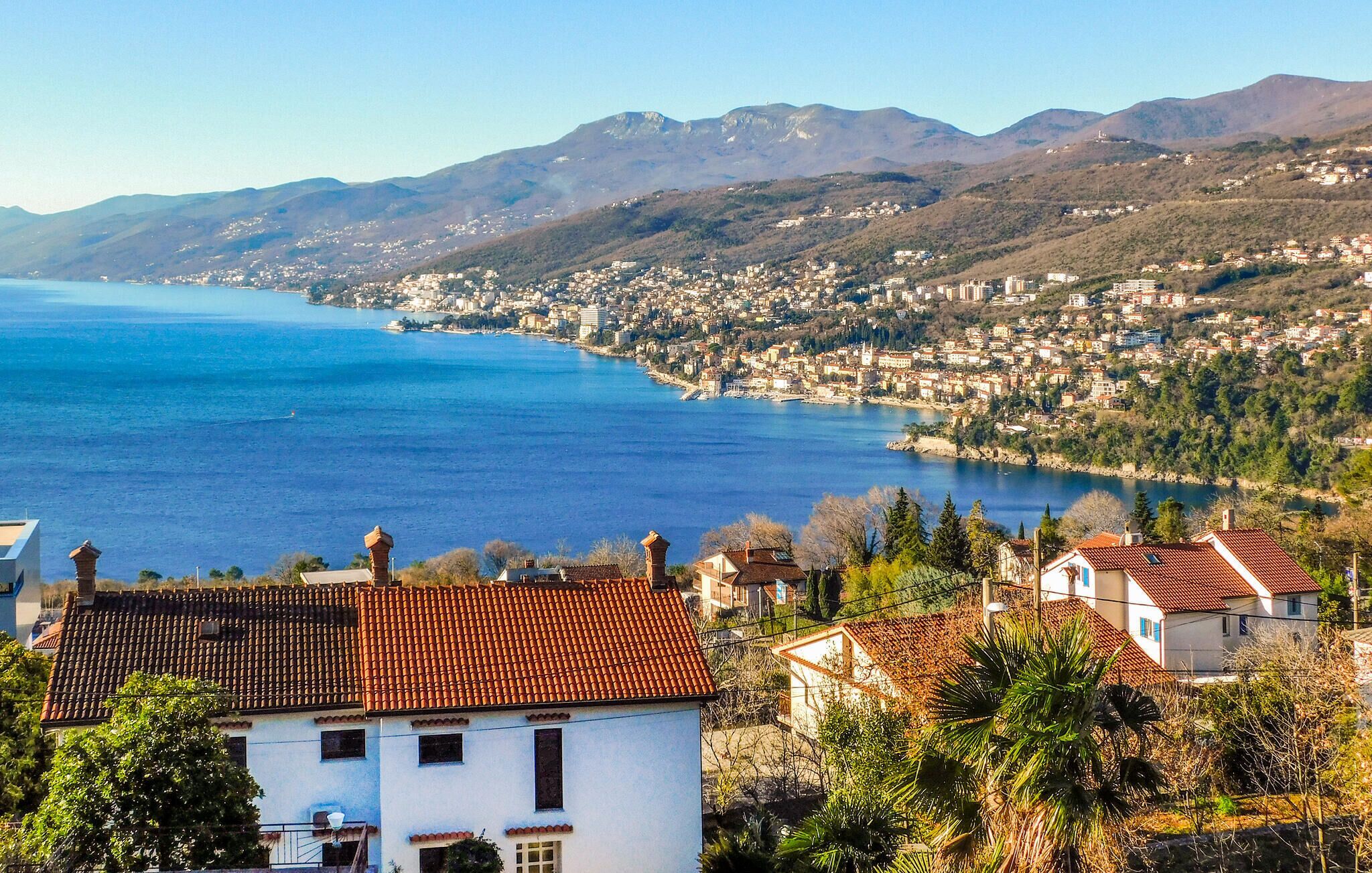 Une ville côtière offrant une vue sur la mer et les montagnes en arrière-plan.