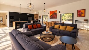 A modern living room with a sofa, coffee table, and dining area.
