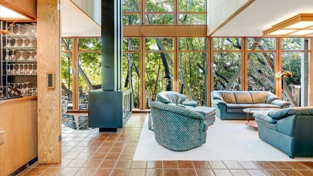 A spacious living area with large windows, a fireplace, and comfortable seating.