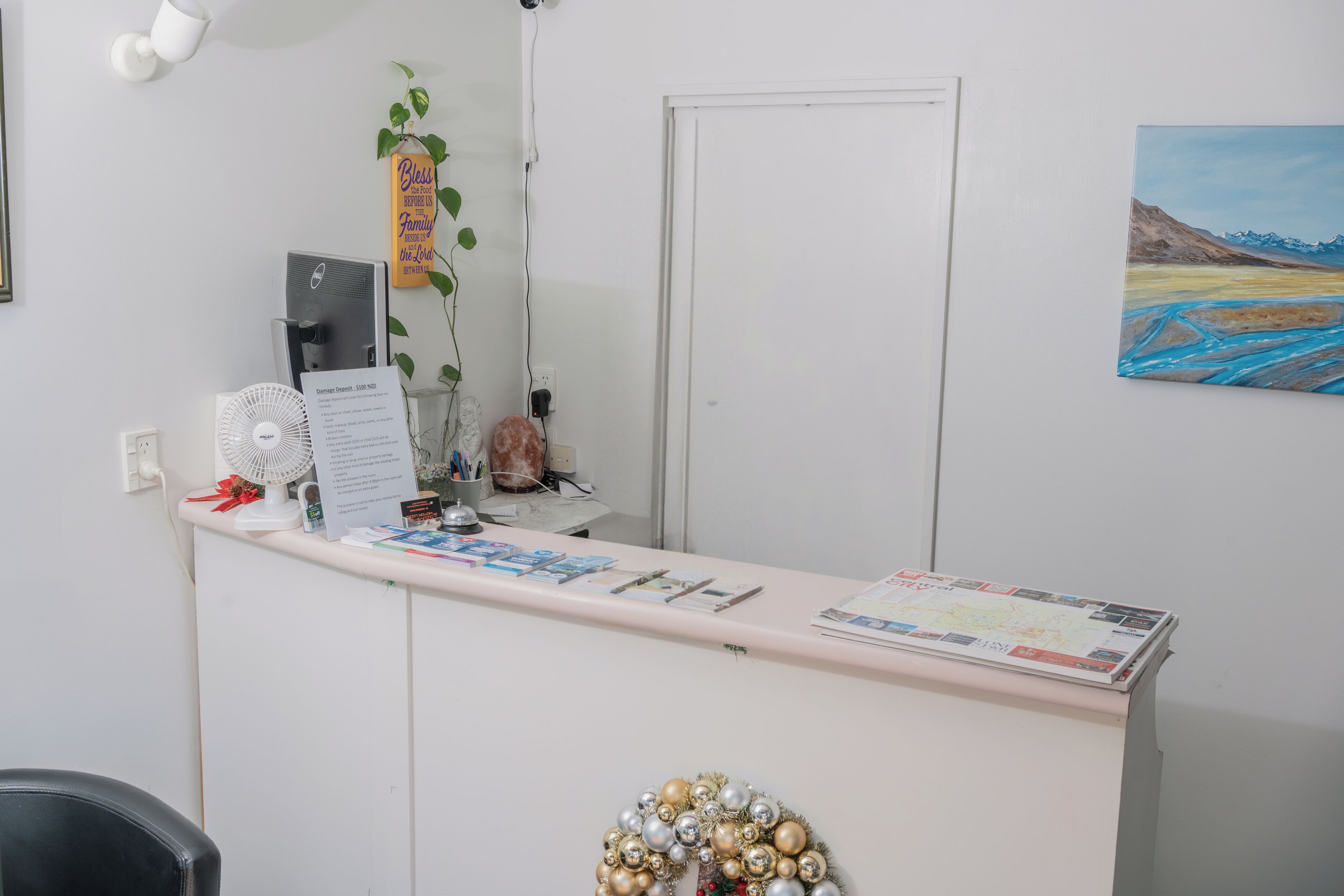 Un comptoir d’accueil avec une carte, un ventilateur et une plante.