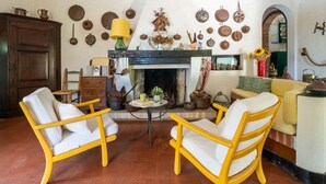 A cozy living room with a fireplace, rustic decor, and traditional furniture.