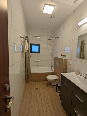 A modern bathroom with a bathtub, toilet, and sink. - Villa BaGalil 3BR Retreat by Sea N' Rent (Yavne'el)