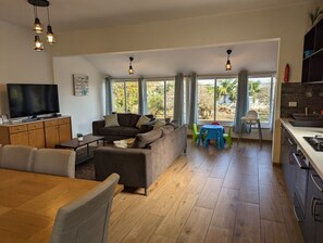 Villa | Woonruimte | Een 65-inch flatscreentelevisie met kabelzenders