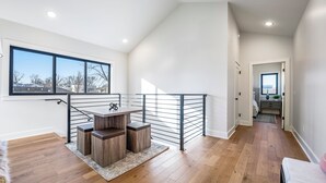 Une chambre de style loft moderne, dotée d’une grande fenêtre, d’un escalier et offrant une vue sur la ville.