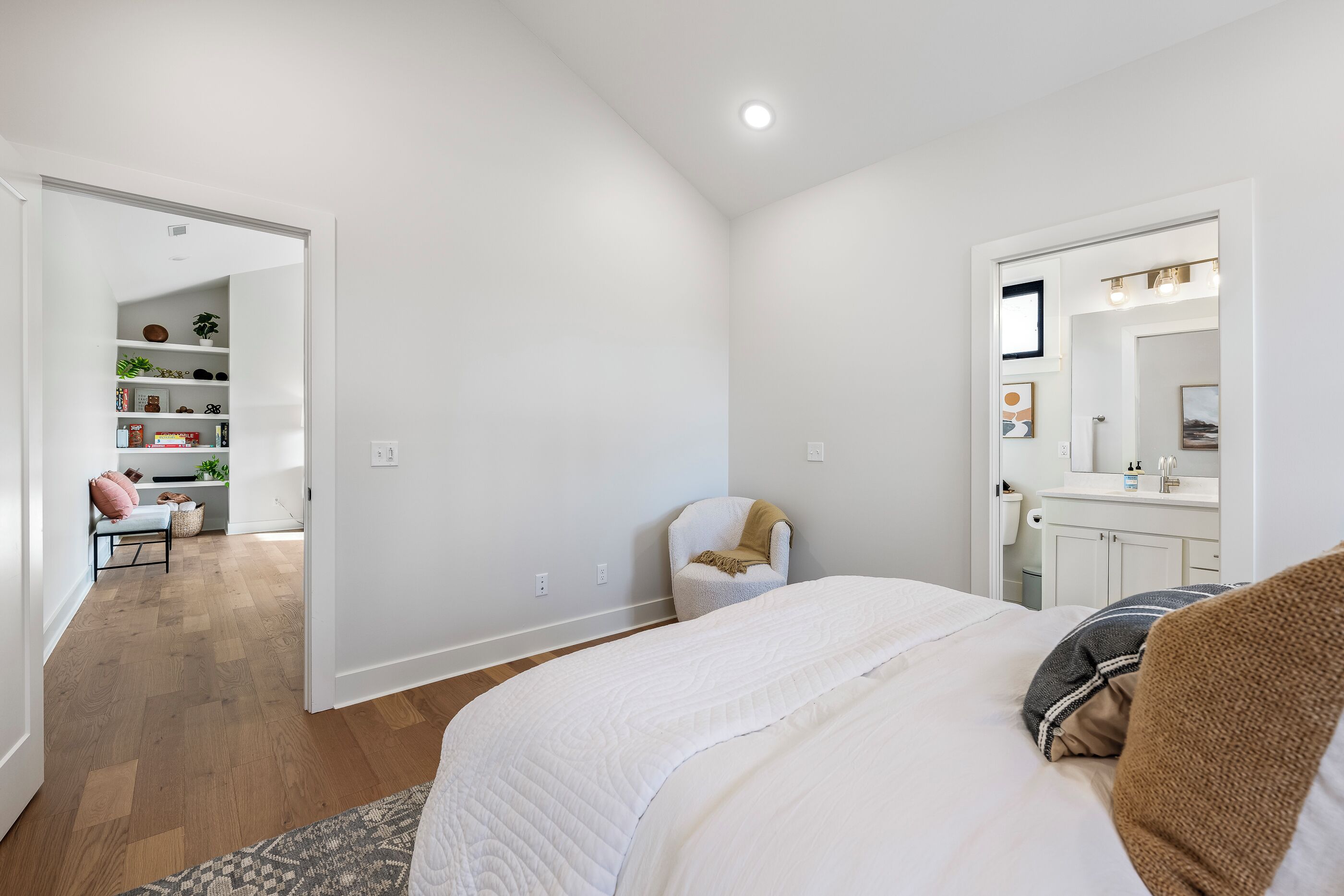 Quarto com cama, cadeira, escrivaninha e estante.