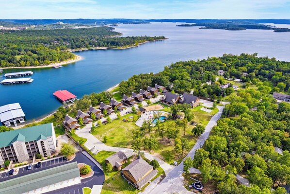 Vista aérea de una zona residencial con casas, piscina y muelle.