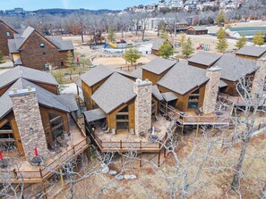 A residential area with multiple log cabin-style houses featuring stone chimneys and wooden decks.
