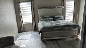 Une chambre à coucher avec un lit, un ventilateur de plafond et une chaise.