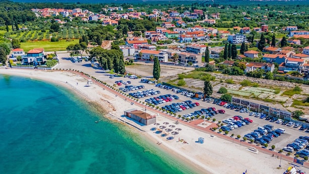 An aerial view of a coastal town with a beach, a parking lot, and residential buildings. - Beautiful home in Fazana (Fazana)