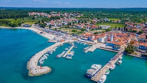 An aerial view of a coastal town with a marina, residential buildings, and a lighthouse. - Beautiful home in Fazana (Fazana)