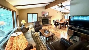 A spacious living room with a fireplace, a television, and a dining area. - Cozy cottage on Bearskin Lake! (Harshaw)