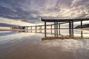 Un muelle se adentra en aguas tranquilas bajo un cielo nublado.