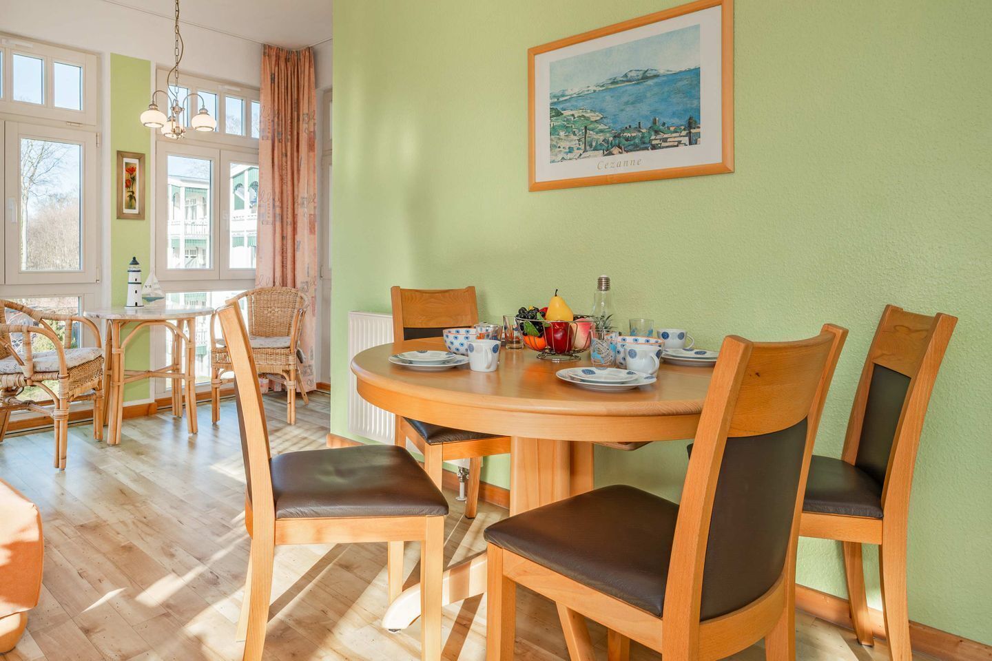 Ein Essbereich mit einem runden Tisch, sechs Stühlen und einem Bild an der Wand.