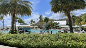 A pool area with palm trees, sunflowers, and lounge chairs. - Beautiful St John Westin Villa - 2 bedroom Bay Vista (Cruz Bay)