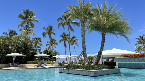 A swimming pool with lounge chairs and umbrellas, surrounded by palm trees. - Beautiful St John Westin Villa - 2 bedroom Bay Vista (Cruz Bay)