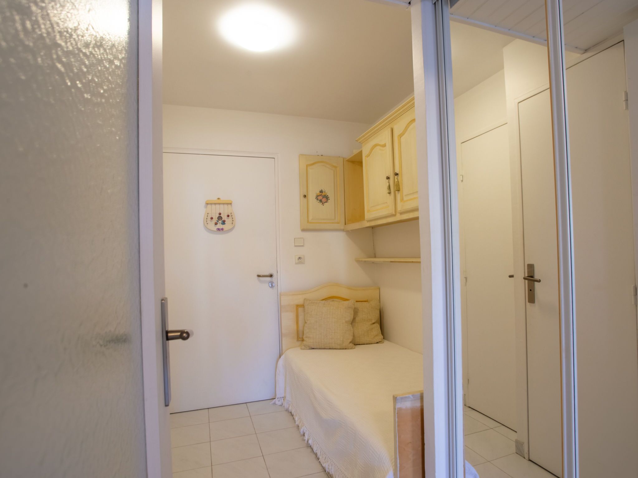 A bedroom with a bed, a wardrobe, and a door.