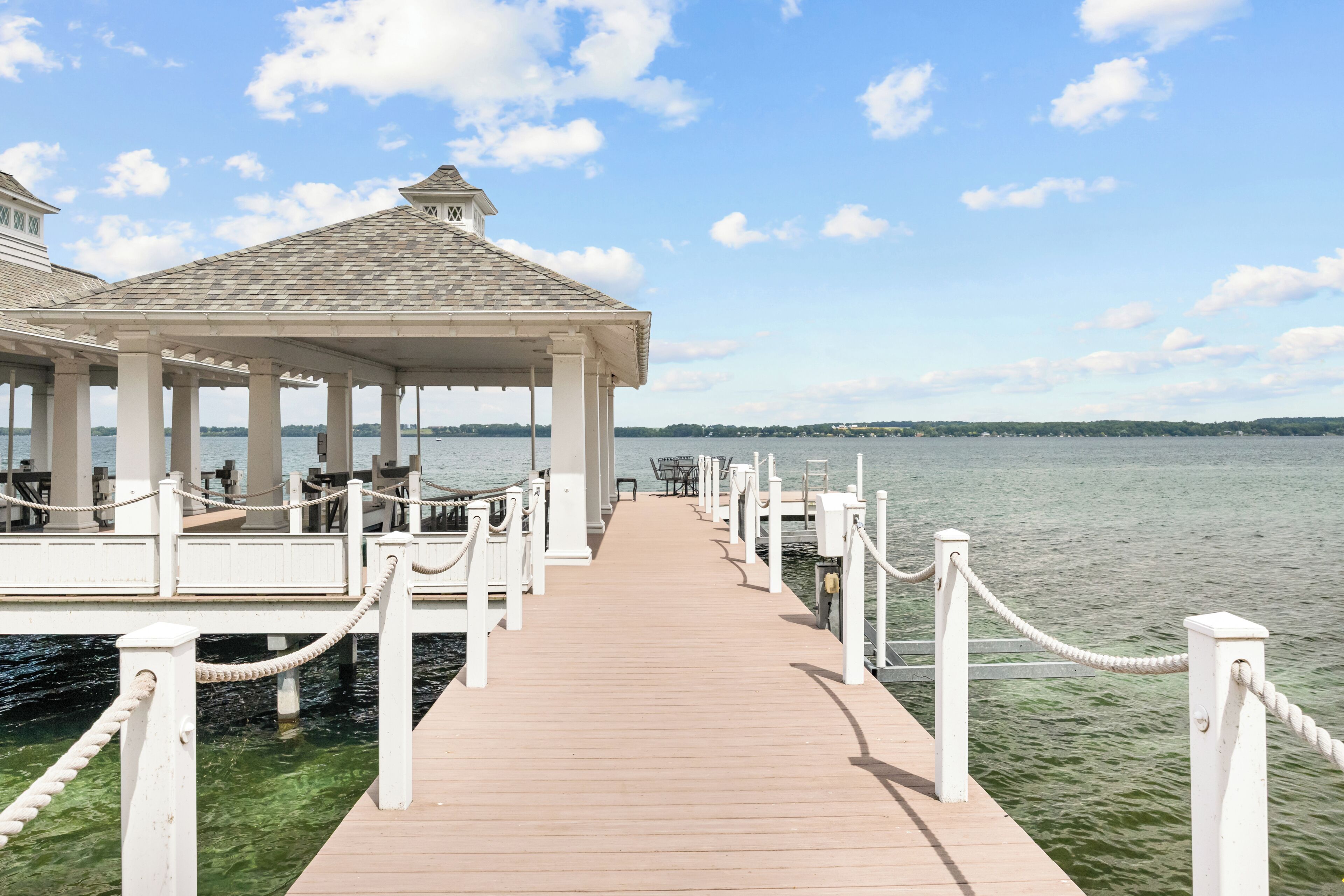A wooden pier leading to a gazebo with a view of the water.