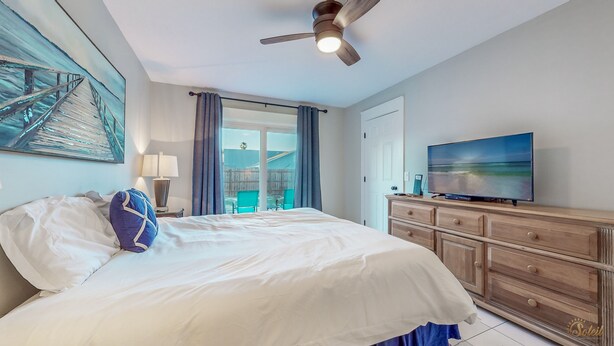 Ein Hotelzimmer mit Bett, Fernseher, Deckenventilator und Blick ins Freie.