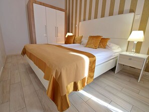 Relax in a stylish room with a large bed, white headboard, and matching nightstand.