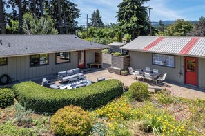 A residential property with a patio area, outdoor seating, and a garden with various plants and flowers. - Belle of the Ball! Biking, Wineries, Westside Hood River! (Hood River)