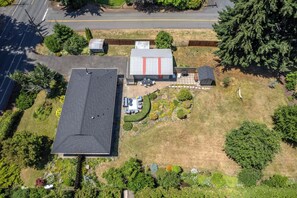 A residential property with a large house, a garage, and a well-maintained garden with various plants and a patio area. - Belle of the Ball! Biking, Wineries, Westside Hood River! (Hood River)