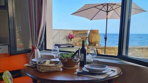 A dining area with a table set for two, overlooking the sea. - Casa Torra d'Erbalunga (Cateri)