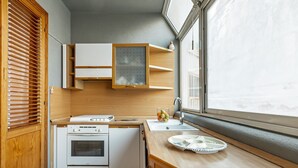 Une cuisine compacte équipée d’une cuisinière, d’un four et d’une fenêtre donnant sur un beau paysage.