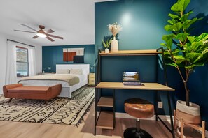 A modern bedroom with a bed, a desk, and a chair.