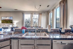 Enjoy cooking in this well-equipped kitchen with a large window, sink, and dishwasher.