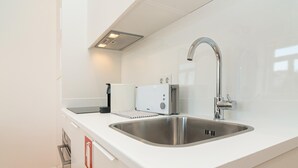 Ett modernt kök med en diskho i rostfritt stål, en brödrost och en vattenkokare.
