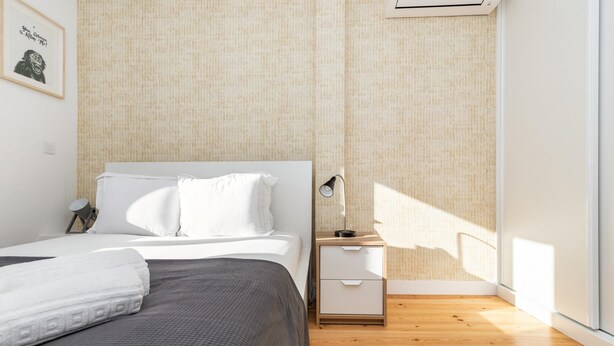 Ein modernes Schlafzimmer mit Bett, Nachttisch und Beistelltisch.
